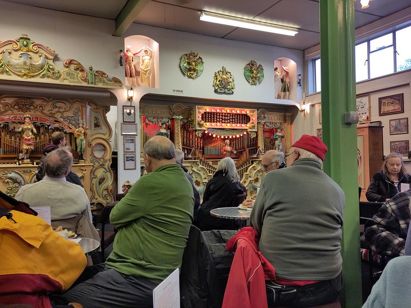 Old people at round tables sorrounded by fair organs